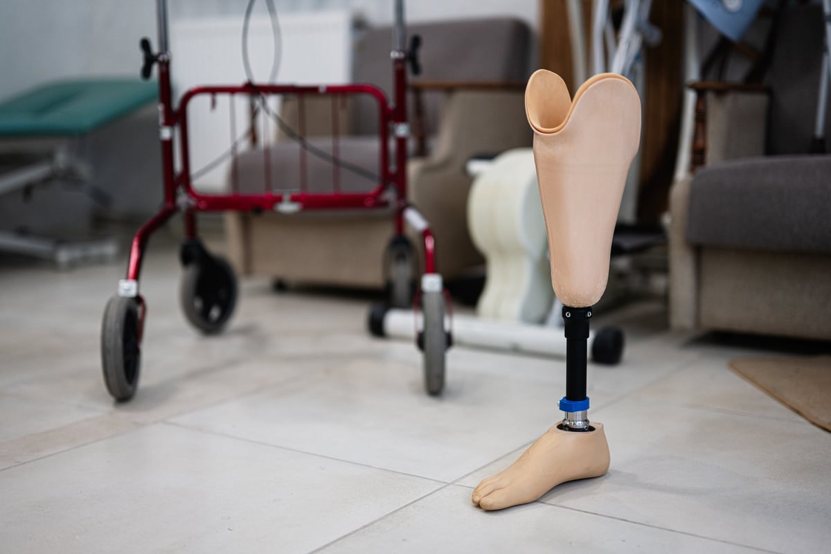 Prosthetic leg standing in a rehabilitation center alongside a walker, symbolizing recovery and mobility support