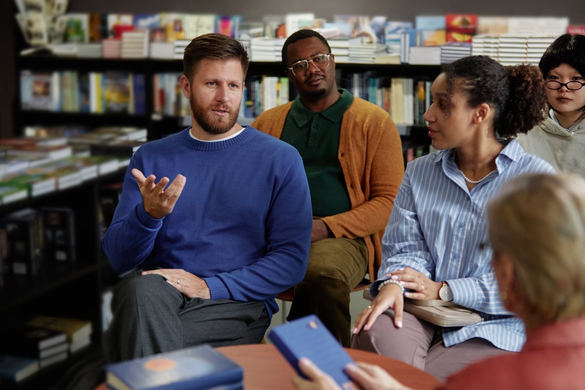 Diverse group engaged in meaningful discussion in a warm, inclusive setting