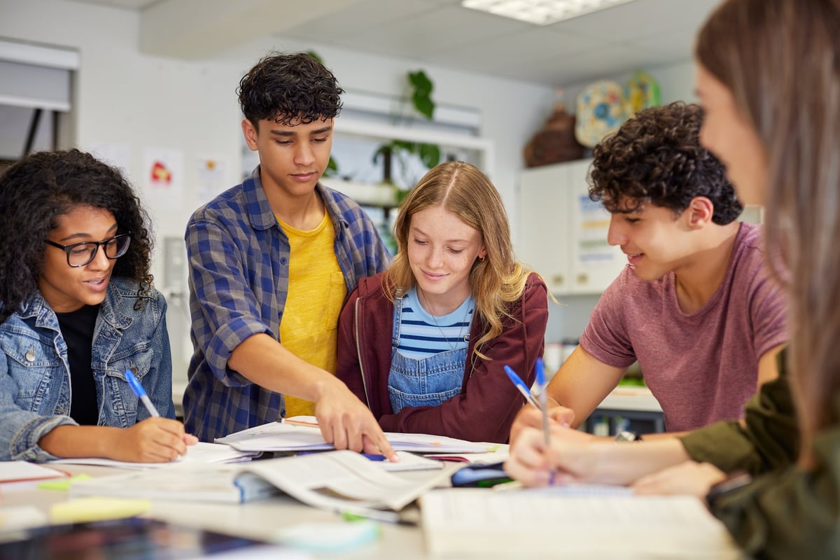 Diverse students collaborating in a study session around a table with open books and notebooks