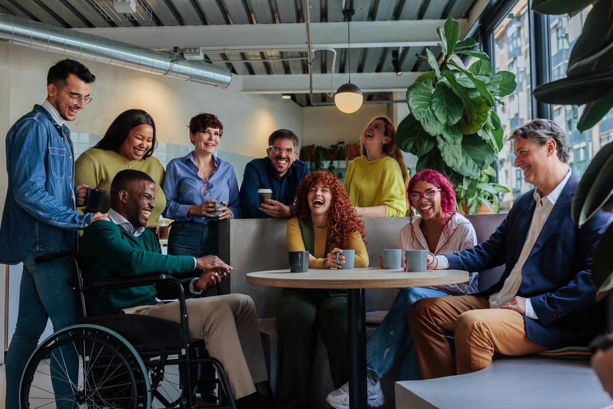Diverse colleagues in a wheelchair accessible workplace — representing what happens when people can arrive, participate and belong