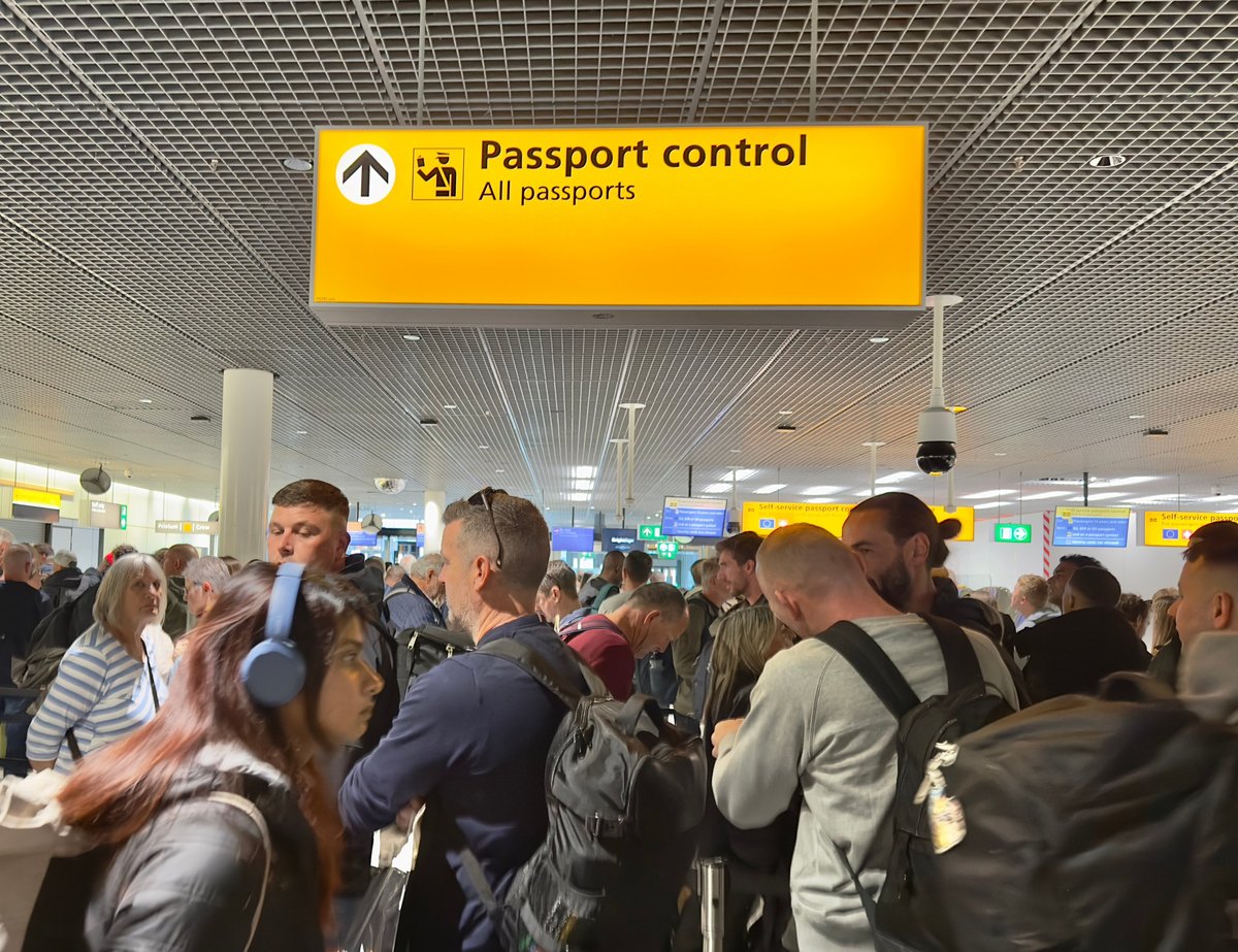 Passengers waiting in a queue to clear Passport Control at Schiphol Airport, Amsterdam